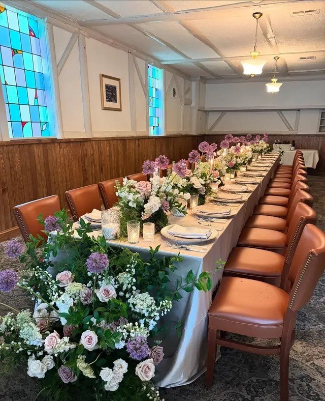Long table with florals beneath the stained-glass windows