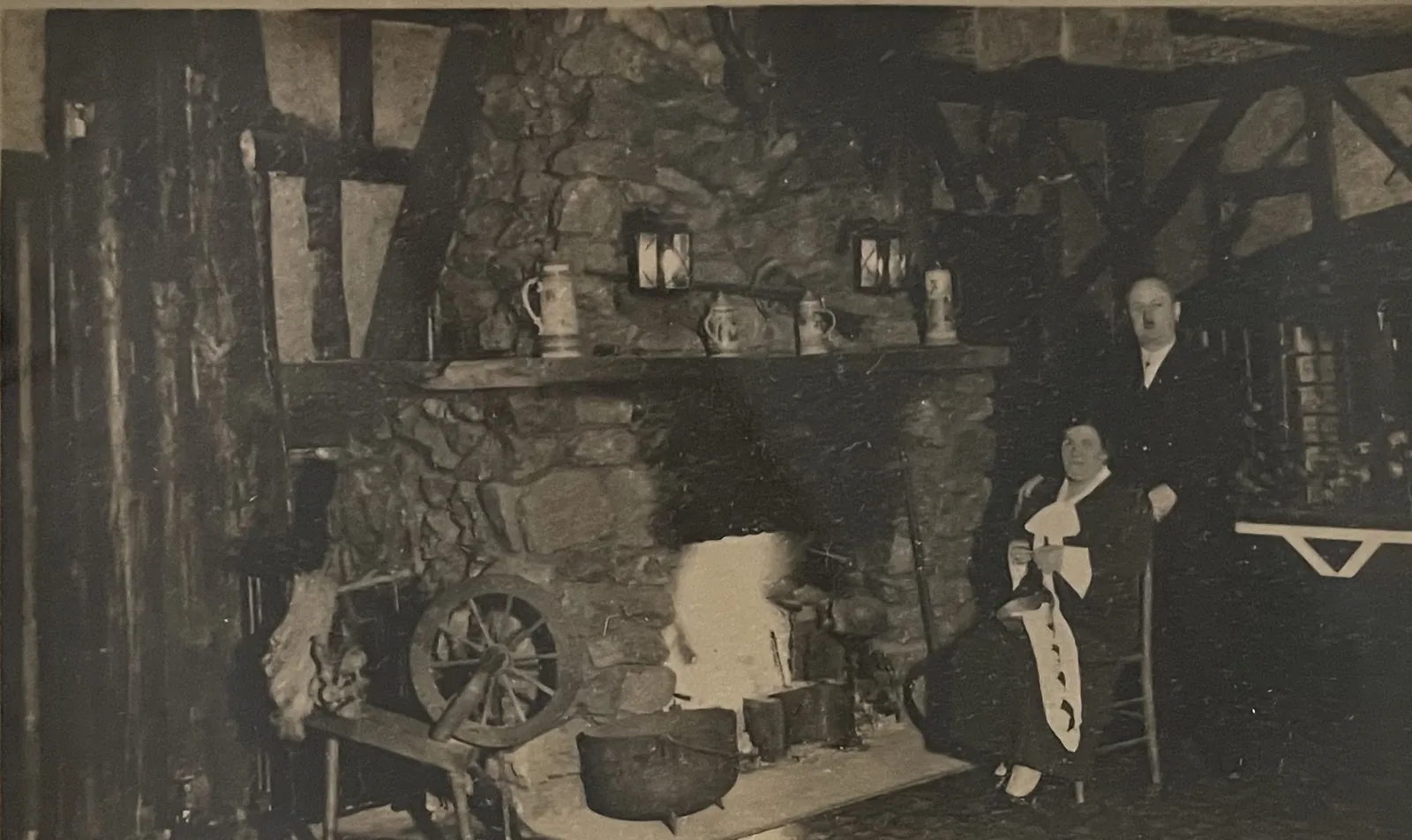 A walk-in stone hearth with a kettle hung over the fire