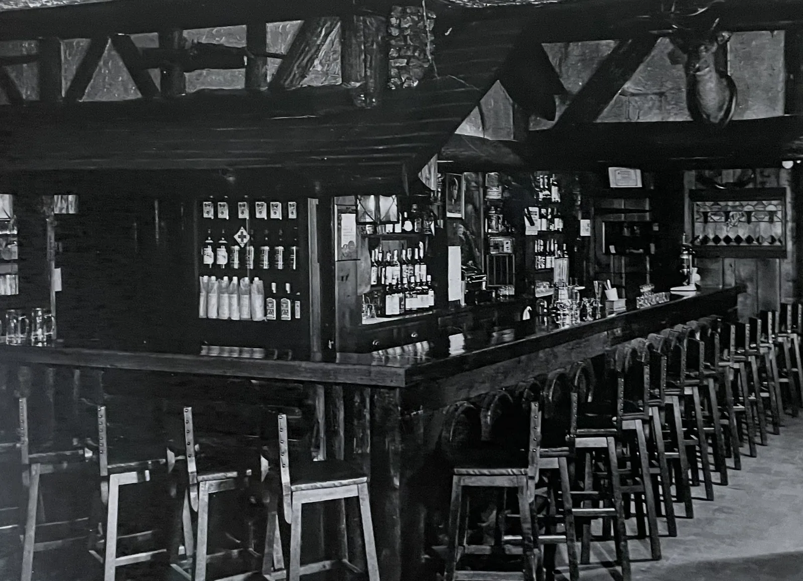 The long Clinton House bar and its stools under heavy beams